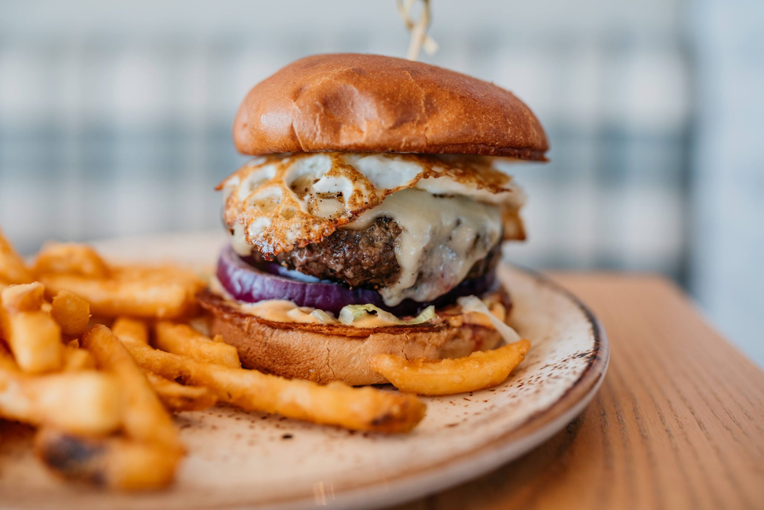 Elk Burger Elk Burger with a fried egg, pepper jack, lettuce, onion, kimchi aioli, and fries