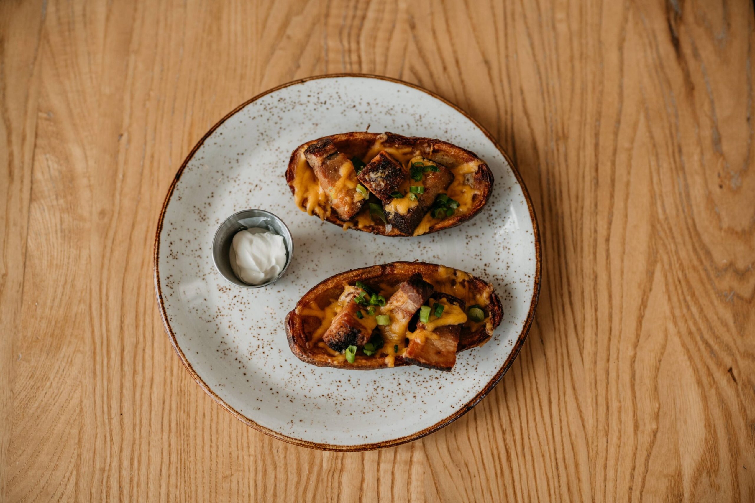 Braised Pork Belly Skins Braised Pork Belly Skins with coffee barbecue braised pork belly, cheddar sour cream, green onion